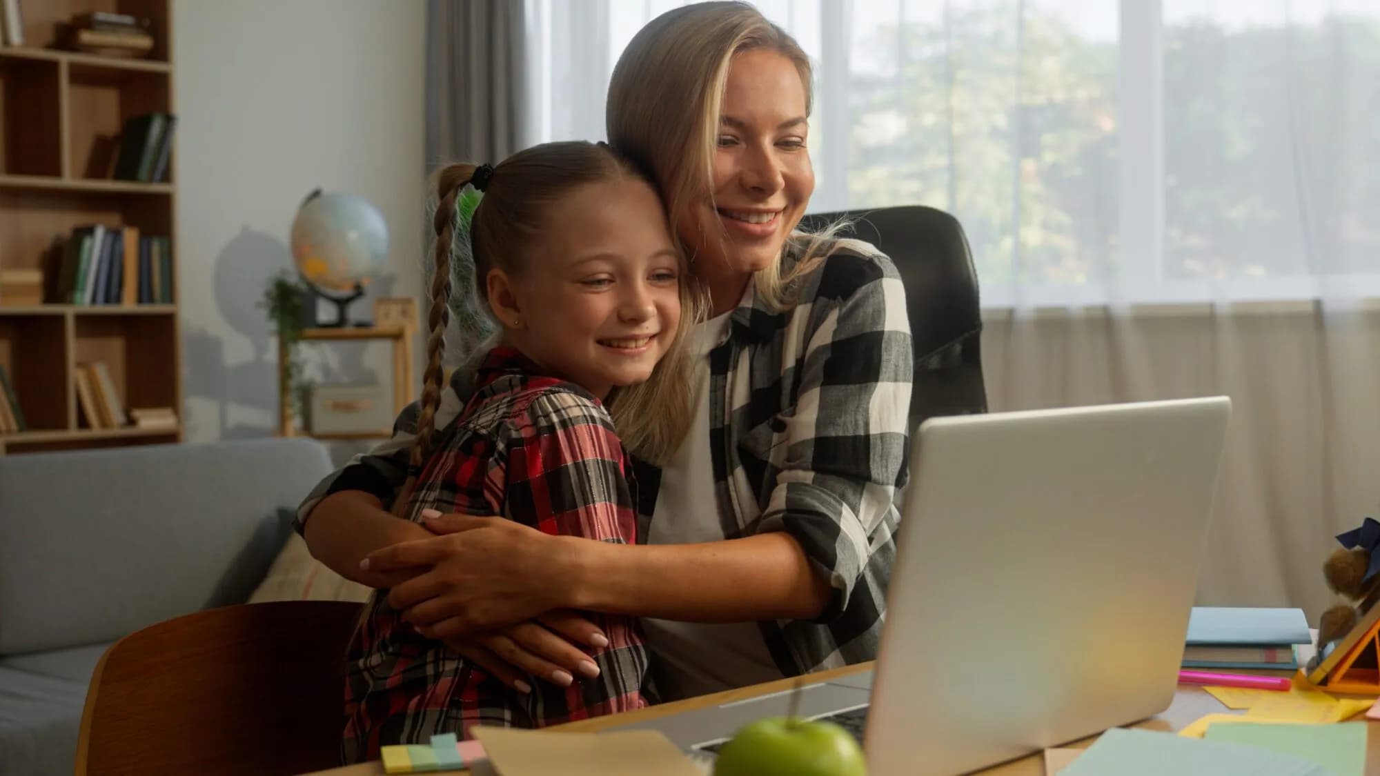 Happy parent mother with daughter child using laptop for school at home